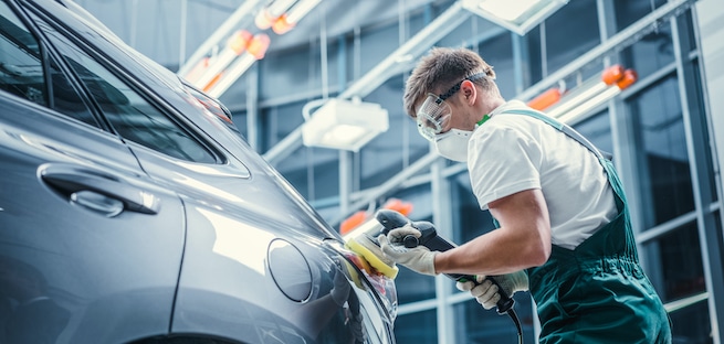 Pro dent removing tech buffing a car